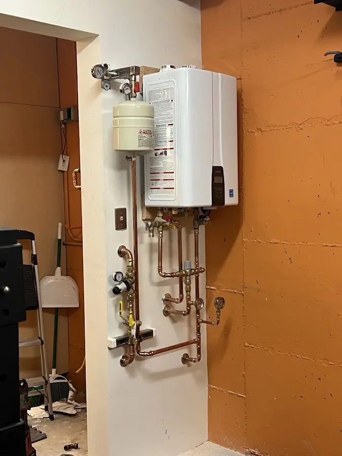 Plumbing technician inspecting water heater connections in Enid